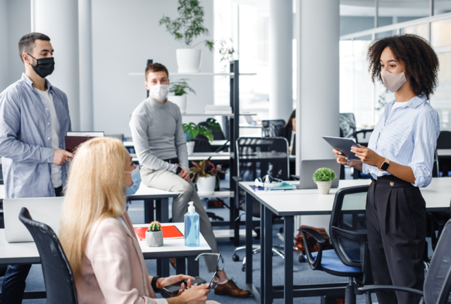Employees in an office setting wearing masks.